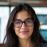 Retrato profesional de Laura Vidal, una mujer joven con gafas sonriendo, de aspecto técnico